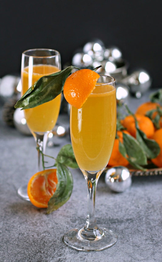 Mimosa shown with orange peel on black background with silver balls around it for decor