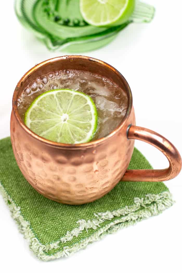Moscow mule in a copper cup pictured on green fabric 