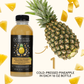 Twisted Alchemy cold-pressed pineapple juice bottle with a pineapple and juice slices on a white background