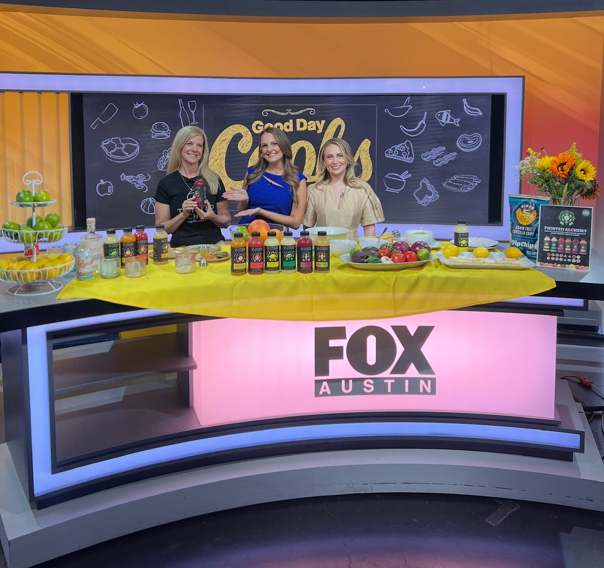 Three women on a TV set with Twisted Alchemy branding and Fox Austin logo.